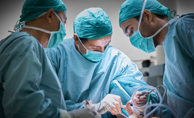 Surgeons operating patient for breast implant